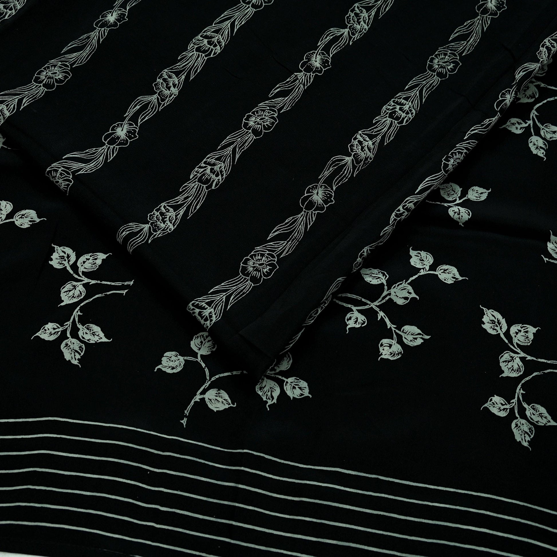 Black pure crepe silk saree fabric with white floral print on a black background