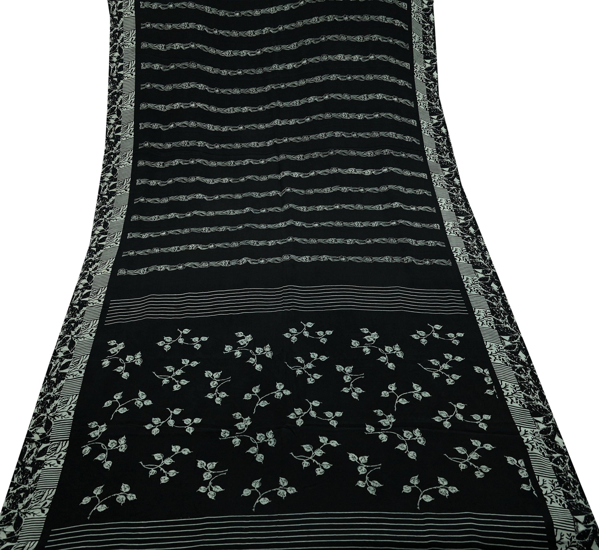 Black pure crepe silk saree fabric with white floral patterns and decorative borders on a white background