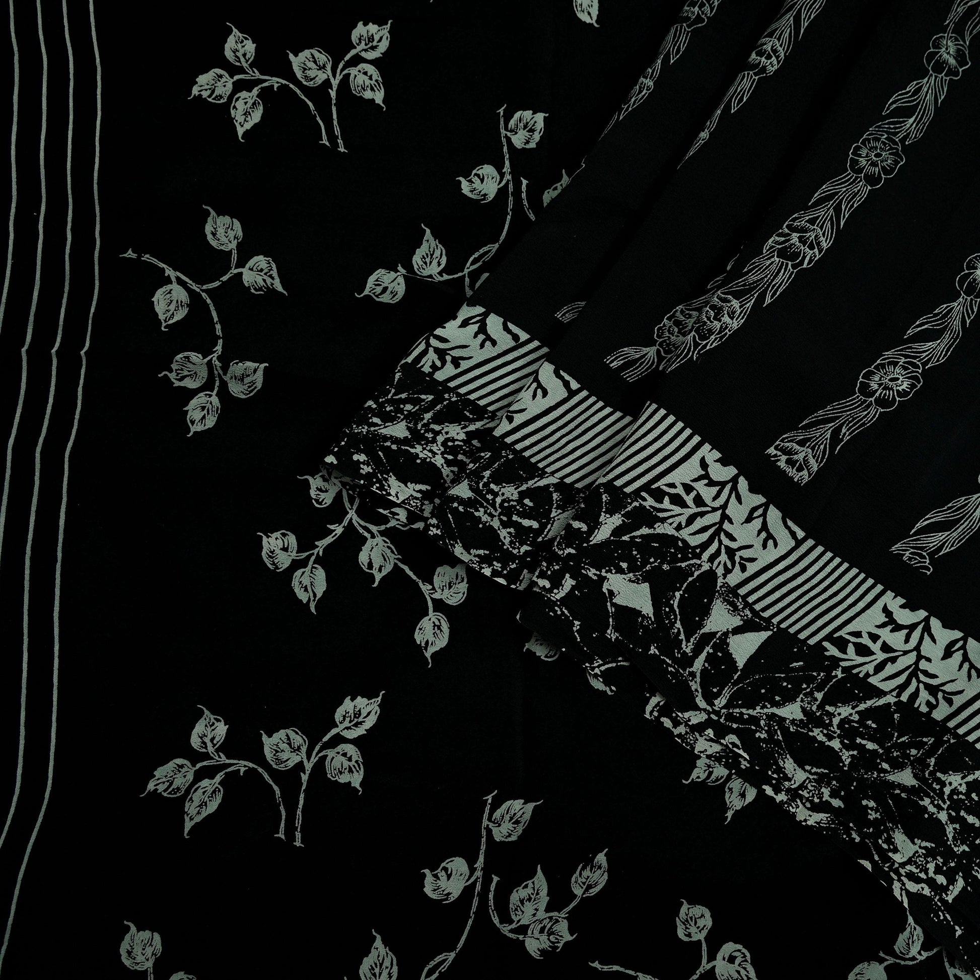 Black pure crepe silk saree fabric with white floral prints on a black background