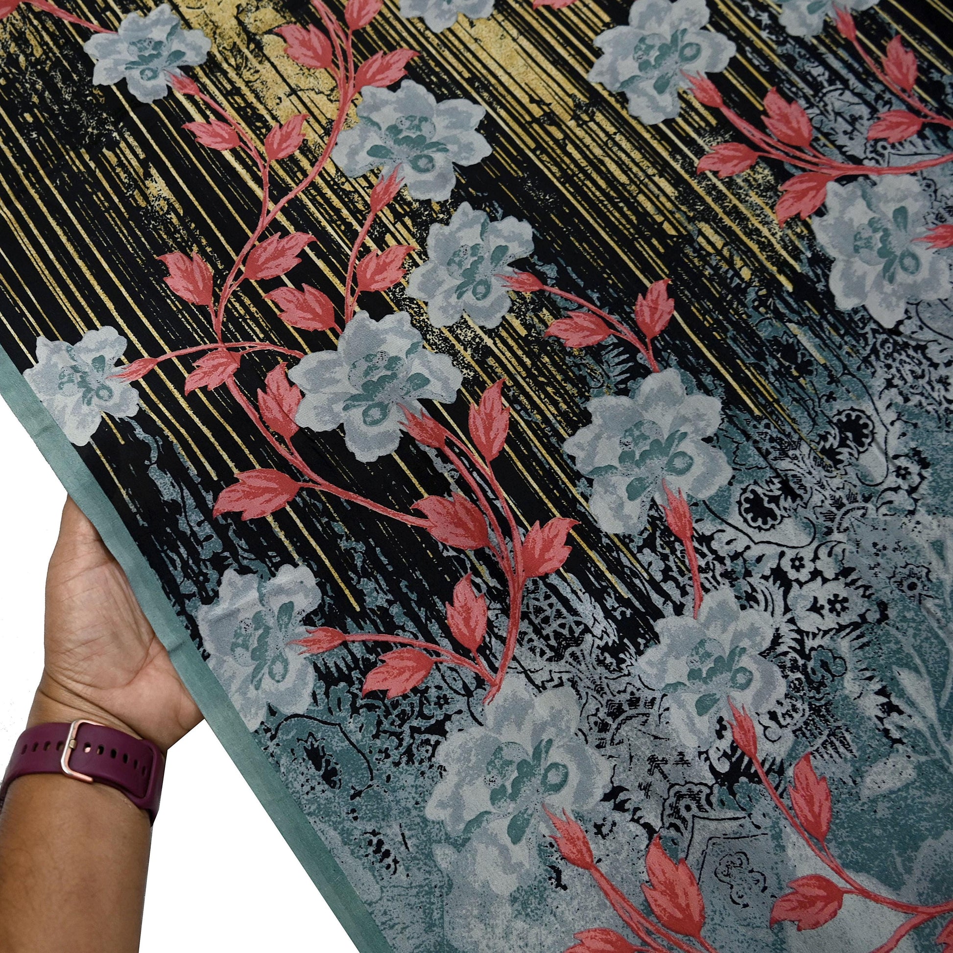 Floral-patterned fabric held by a hand.
