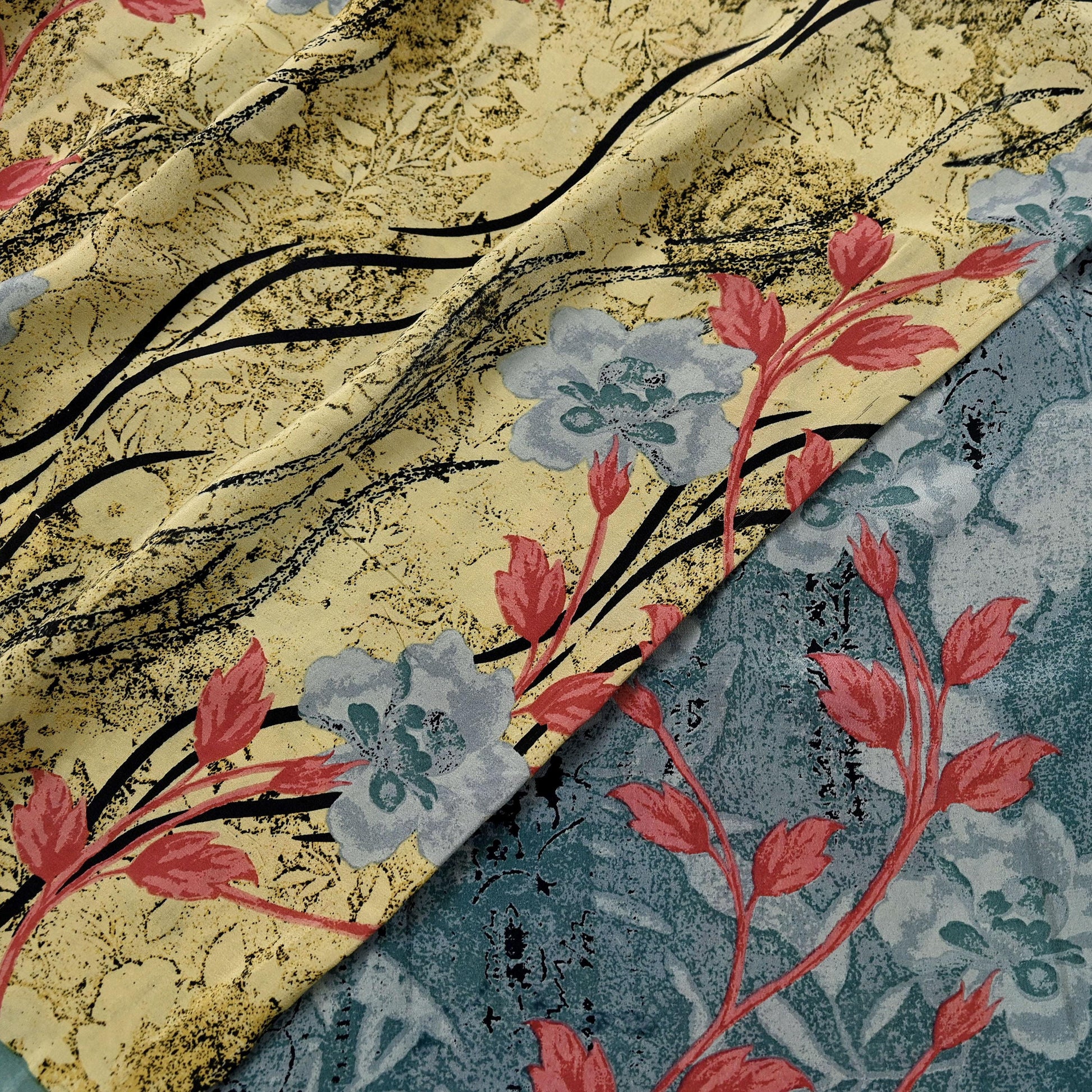 Two floral patterns of the same printed silk saree shown side-by-side, one gold and black, the other blue and red.