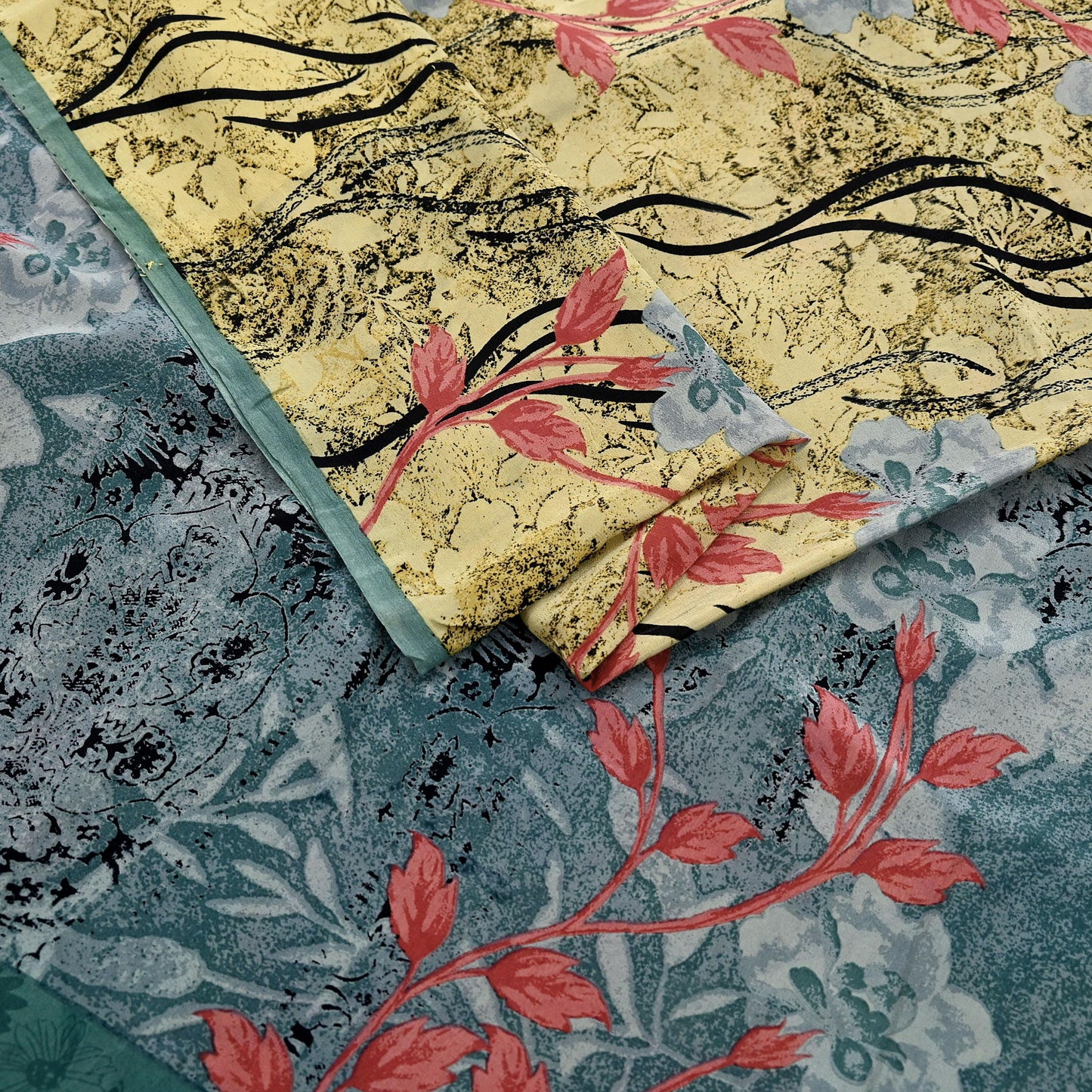 Close-up of fabric with floral patterns in yellow, red, and blue on a textured background.
