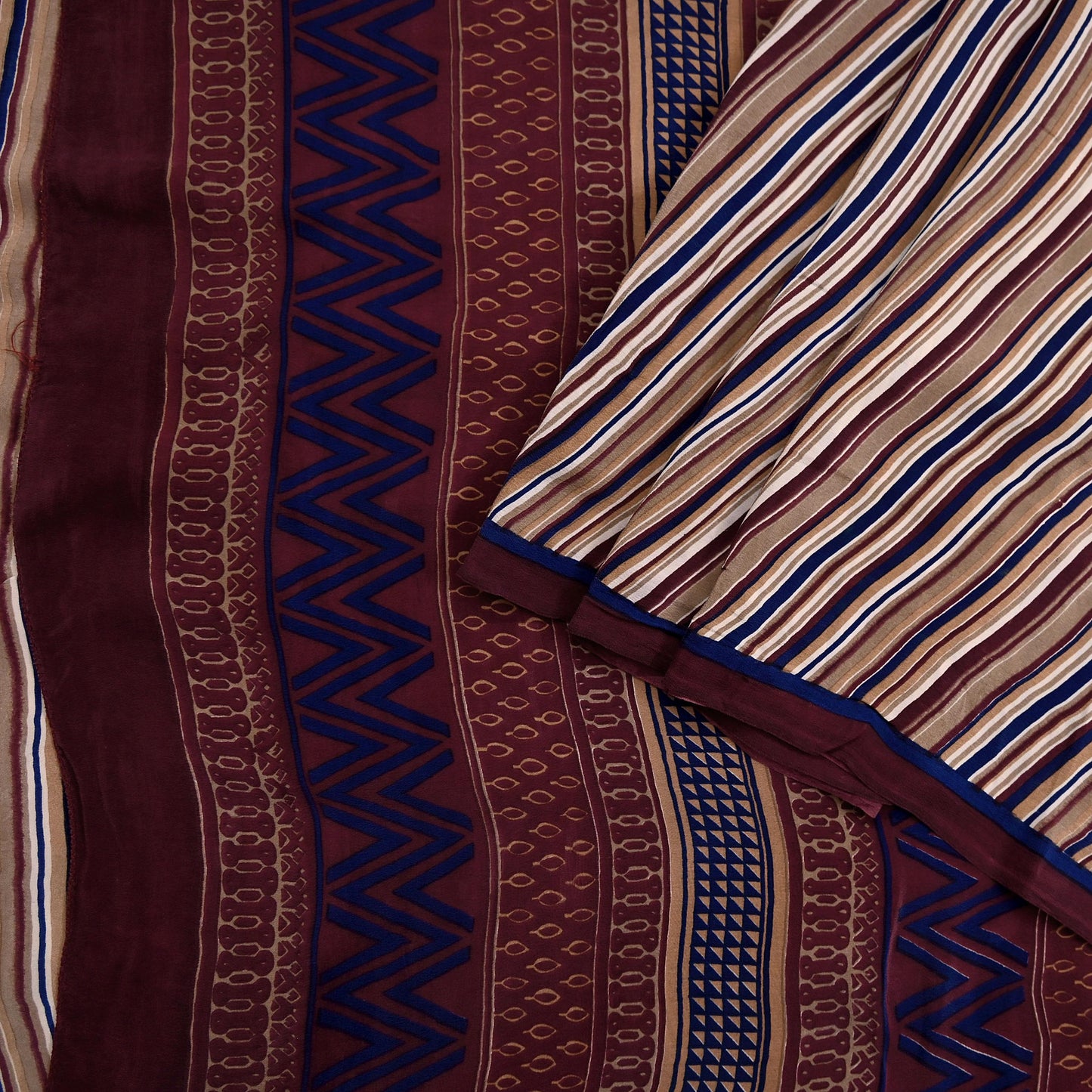 Close-up of patterned fabric with zigzag and stripe designs in brown, blue, and beige.