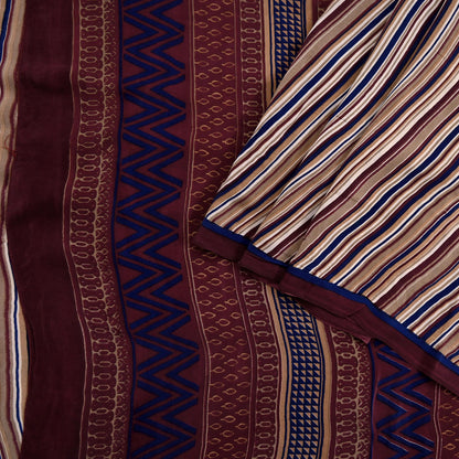 Close-up of patterned fabric with zigzag and stripe designs in brown, blue, and beige.