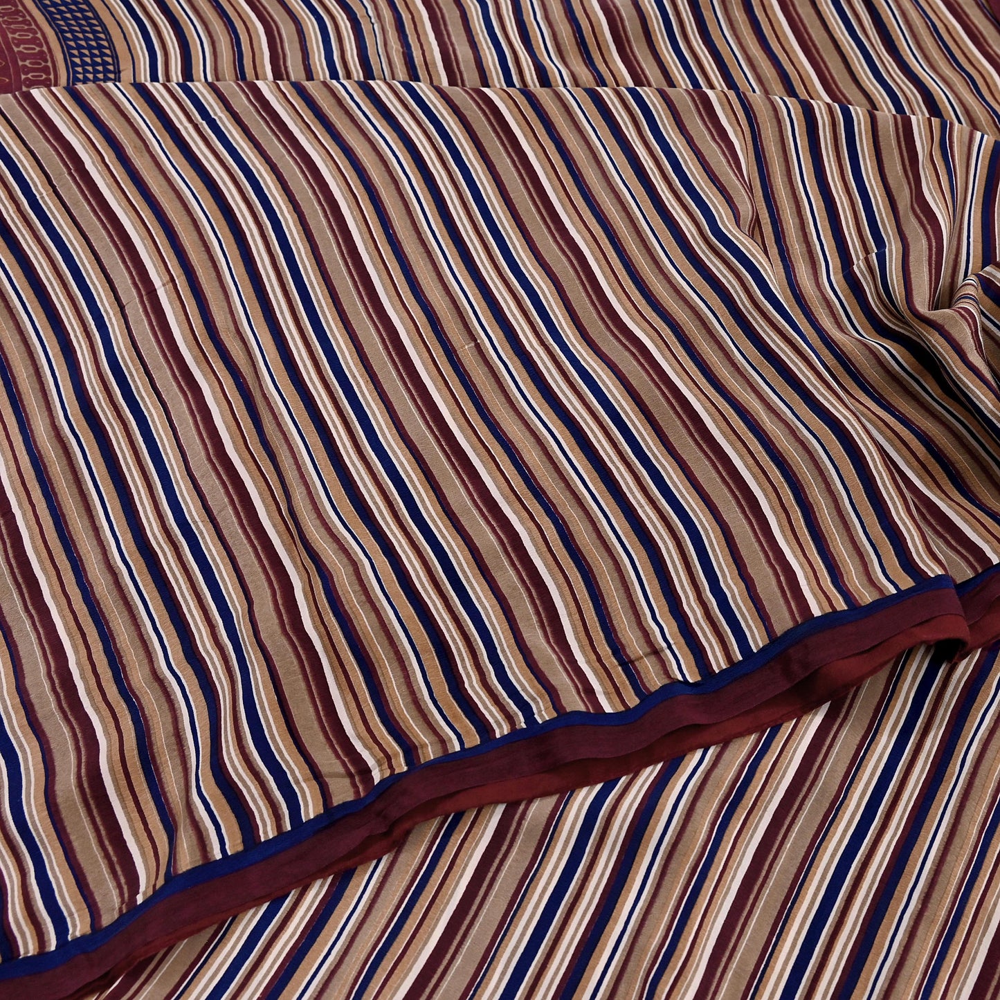 Close-up of striped fabric with brown, blue, and red colors.