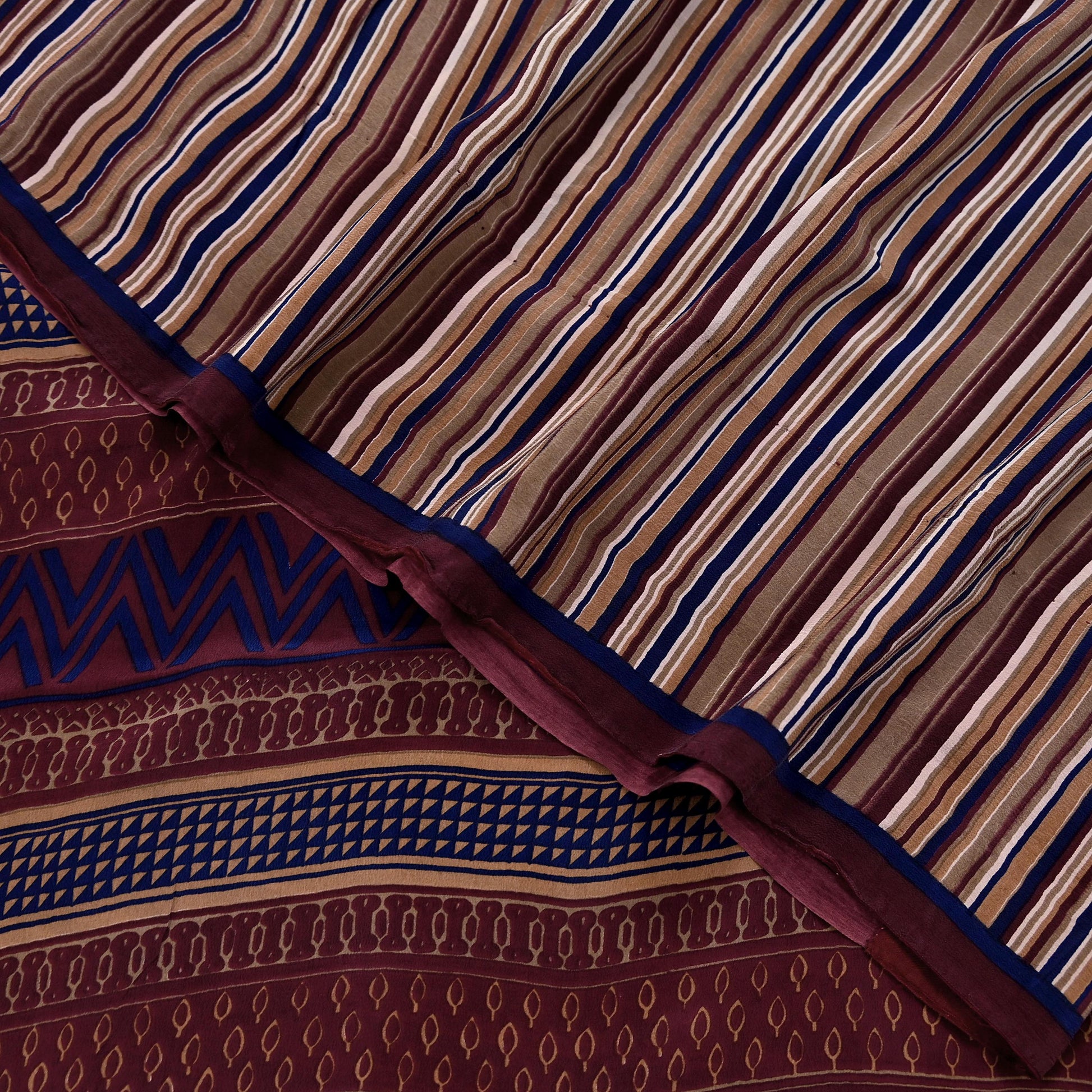 Close-up of patterned fabric with brown, blue, and beige colors.