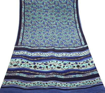 Blue and green patterned pure crepe silk saree fabric with stripes and floral designs on a white background