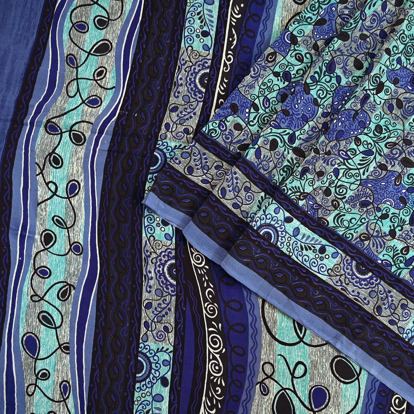 Close-up of a vintage pure crepe silk saree fabric with intricate blue and green patterns