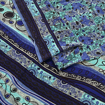 Close-up of patterned pure crepe silk saree fabric with blue, black, and green colors.