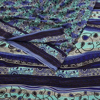 Patterned pure crepe silk saree fabric with blue and green designs on a flat surface