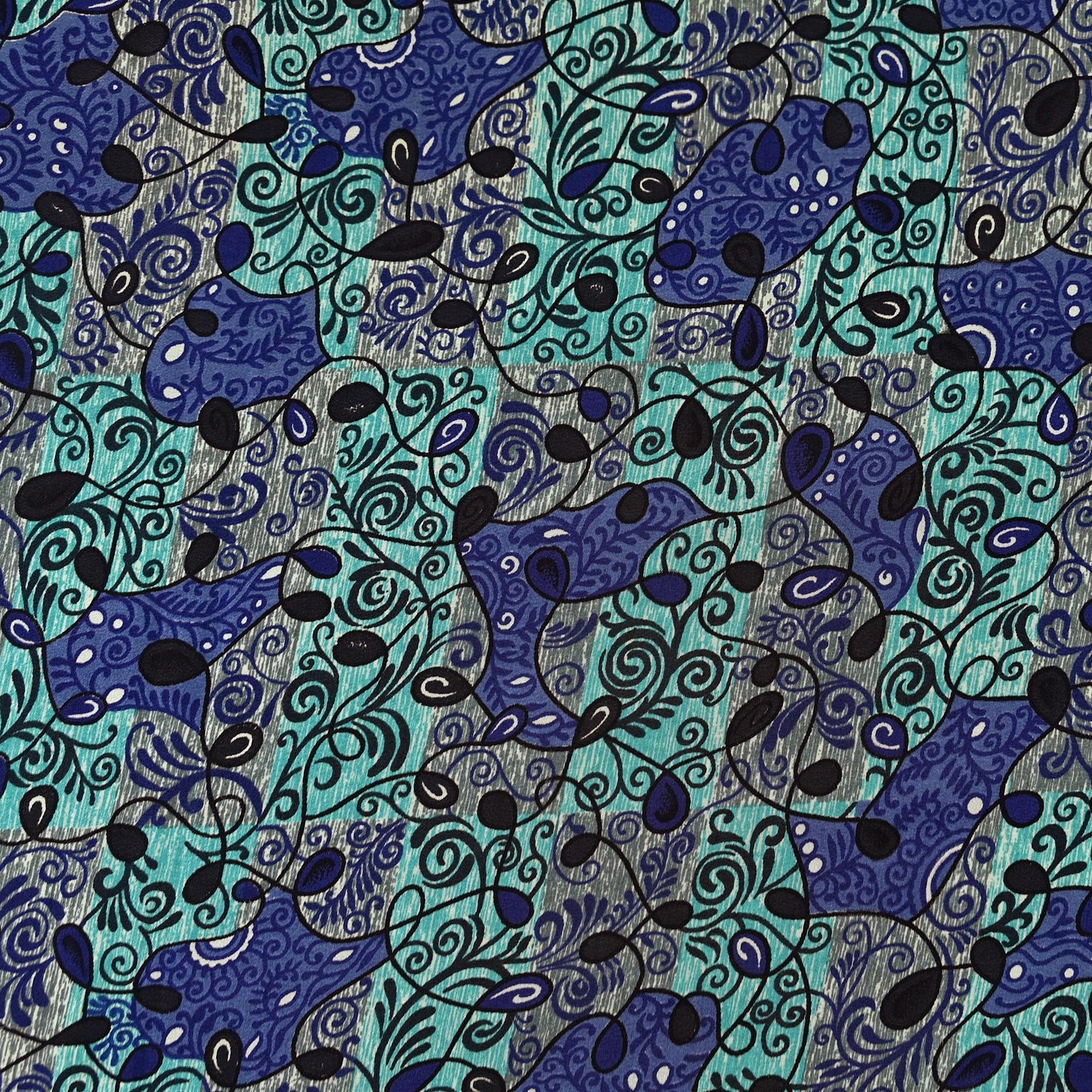 Close-up of a patterned pure crepe silk saree fabric with blue and black abstract and floral designs