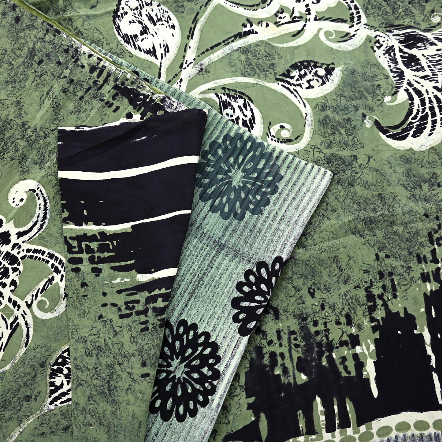 Black and white striped design on a textured green pure crepe silk saree fabric with floral patterns