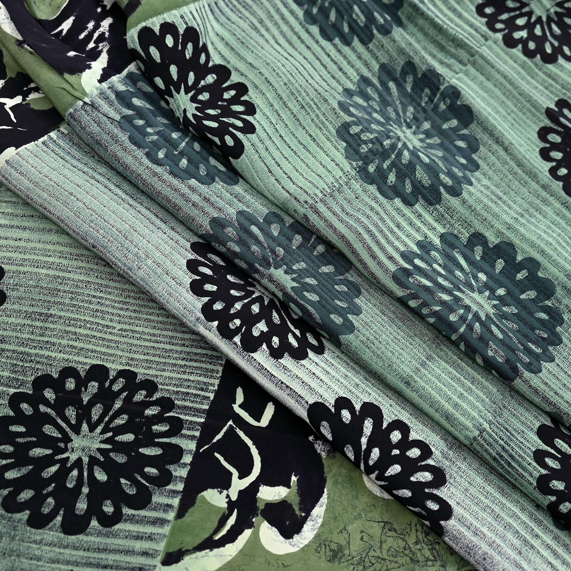 Vintage pure crepe silk saree with black floral patterns on a green and gray striped background