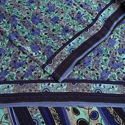 Close-up of a patterned pure crepe silk saree fabric with blue and green design