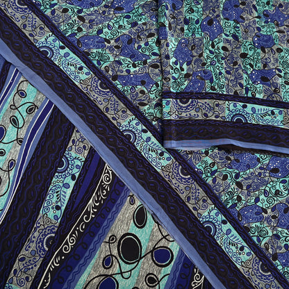 Close-up of a patterned pure crepe silk saree fabric with blue and green design
