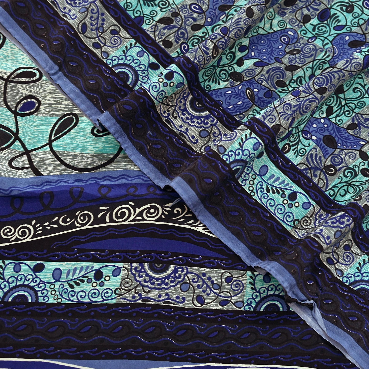 Close-up of a pure crepe silk saree fabric with intricate blue and black patterns