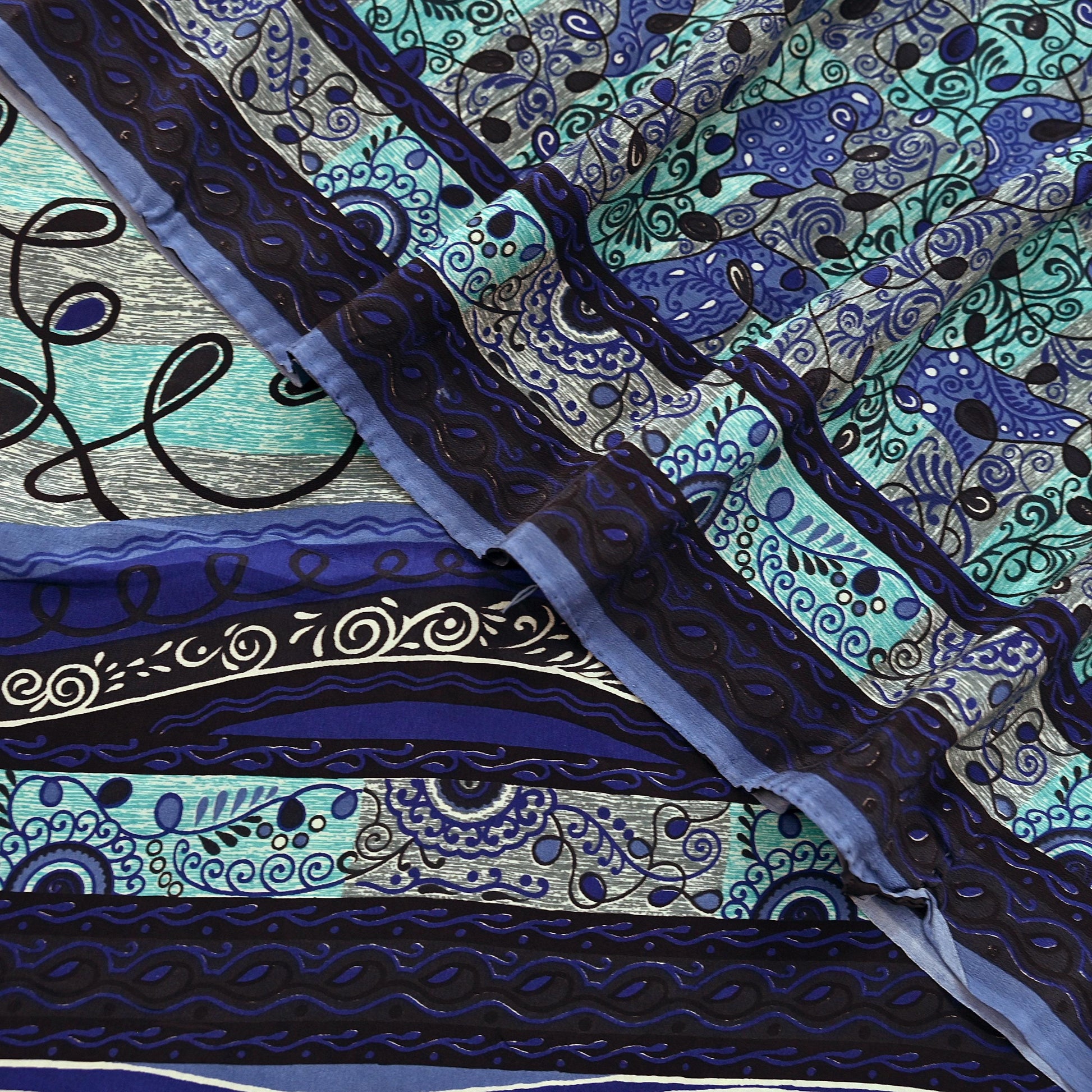 Close-up of a pure crepe silk saree fabric with intricate blue and black patterns