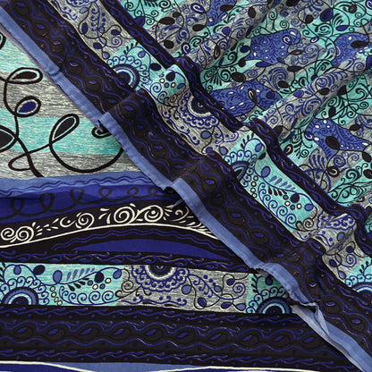 Close-up of a pure crepe silk saree fabric with intricate blue and black patterns