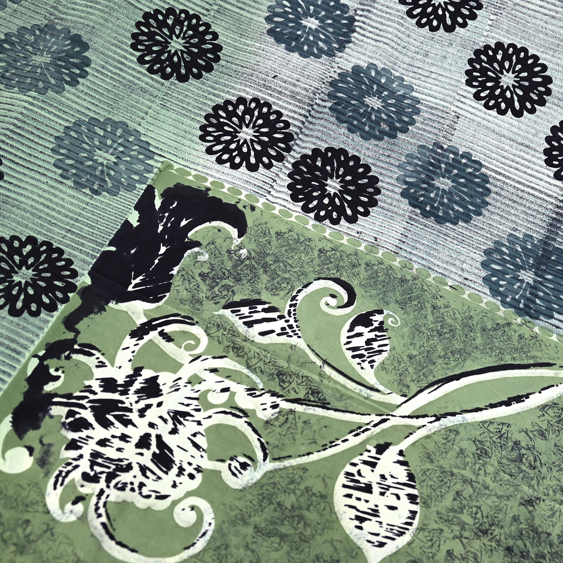 Decorative pattern with black floral design on a green and blue background